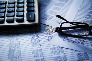 Laptop and glasses resting on financial report