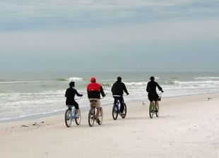 Members of a team riding their bikes on a beach